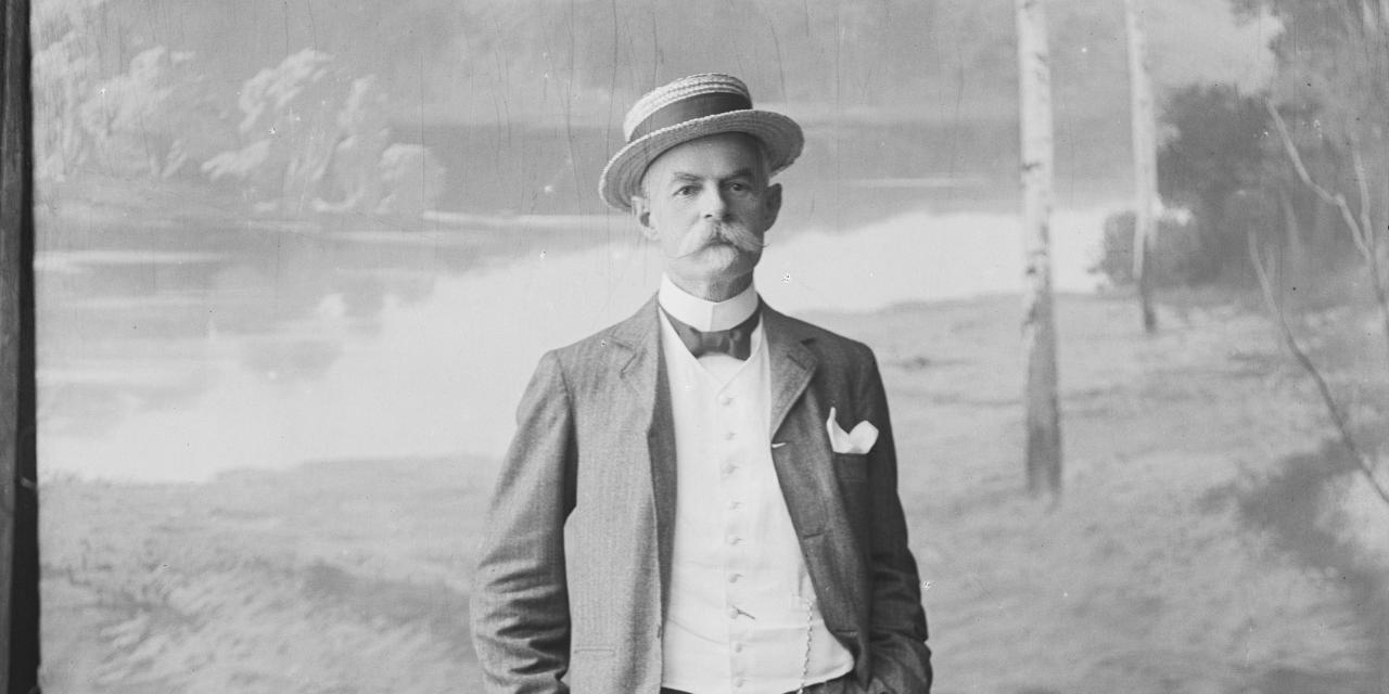 Portrætfotografi af en ældre herre i fint tøj med en naturbaggrund.