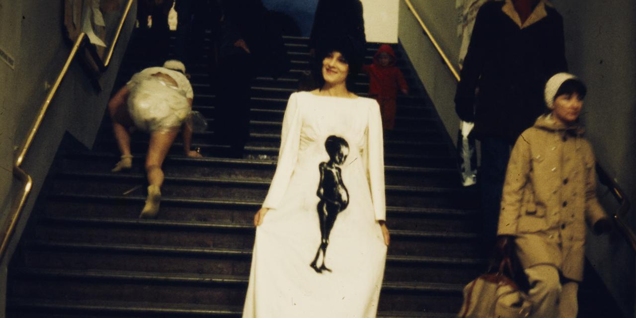 Woman in white dress on stairs.