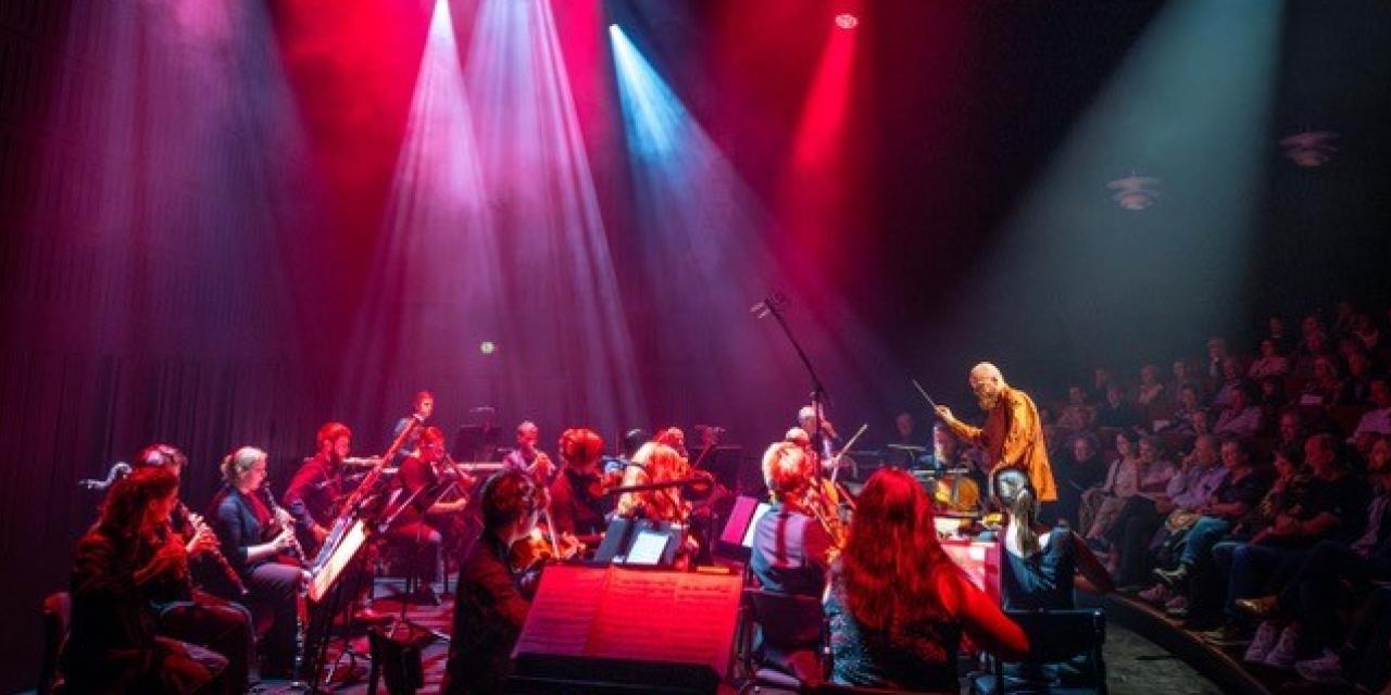 Aarhus Kammerorkester i på scenen badet i rødt lys.
