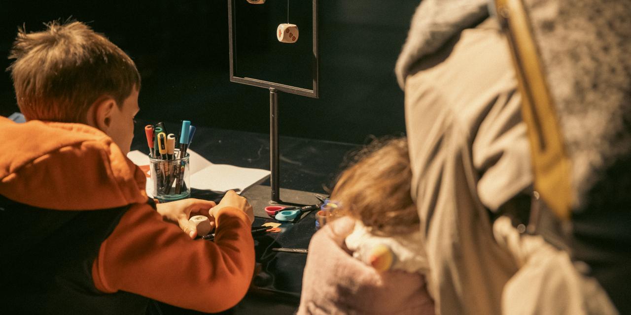 To børn sidder og tegner ved et bord.