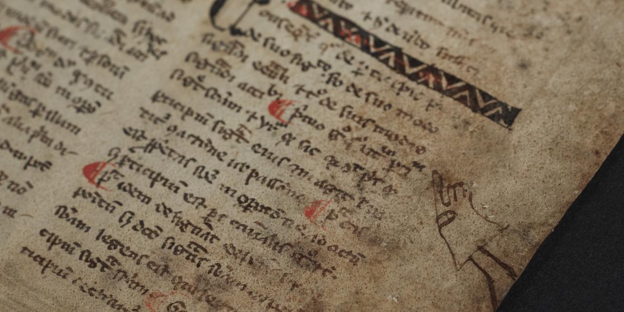 Close up af fragmentet, hvor man kan se en lille behandsket hånd som peger på en særlig vigtig passage.