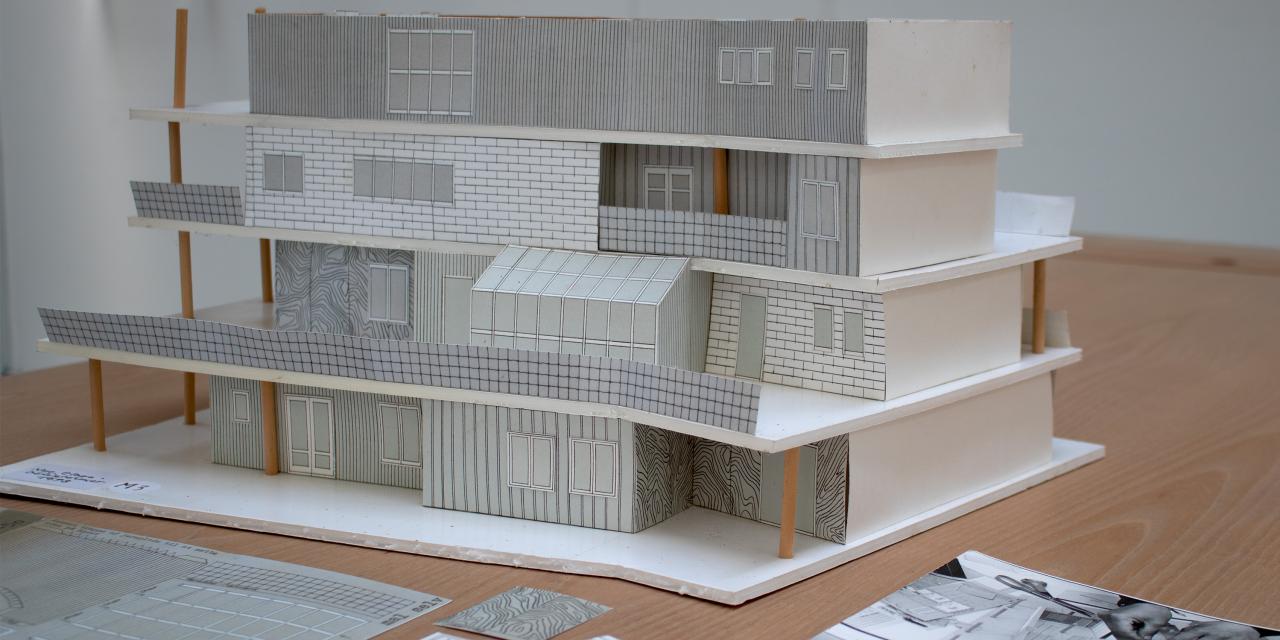 Miniature model af et hus i fire etager. 