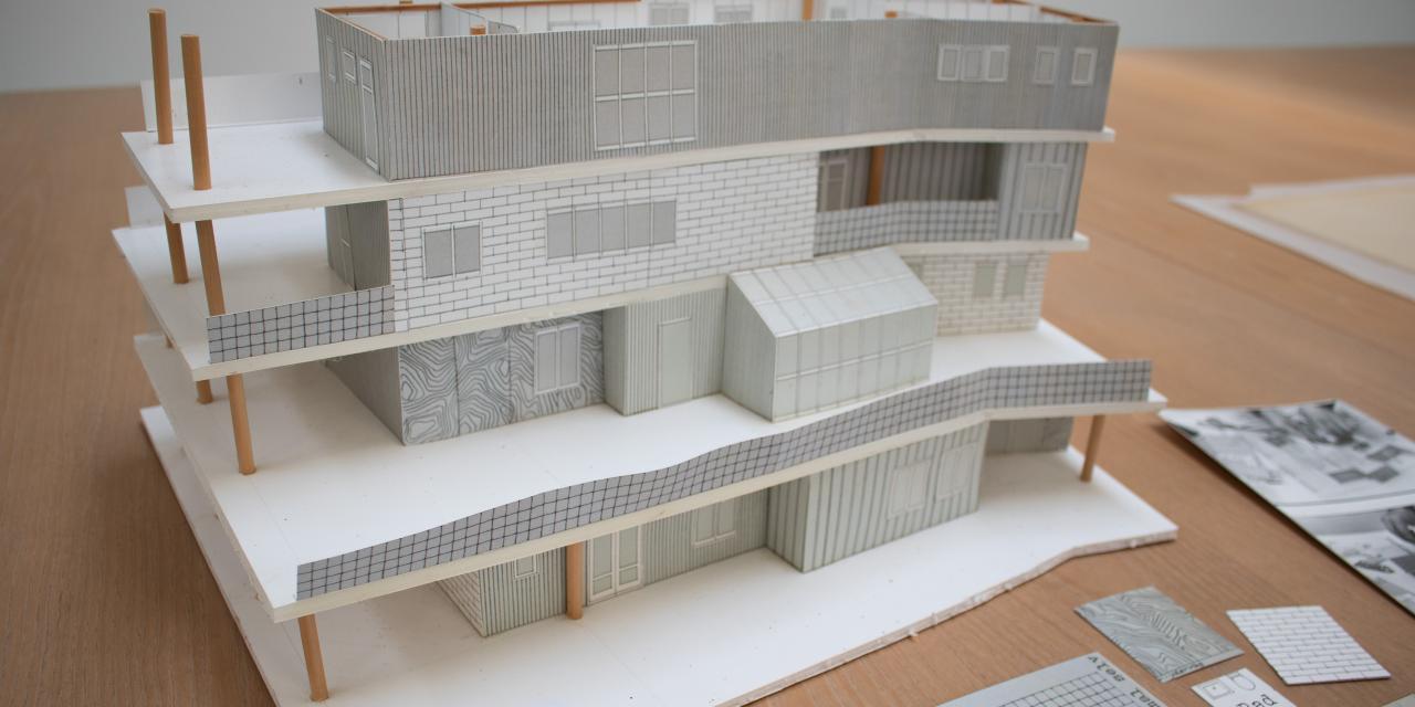 Miniature model af et hus i fire etager. 