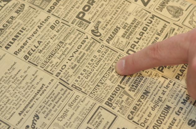 Finger points to text in newspaper