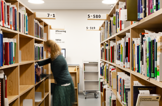 Collaboration with book trolley among shelves