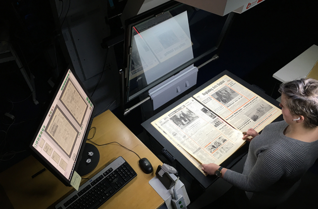 Medarbejder i færd med digital affotografering af avis