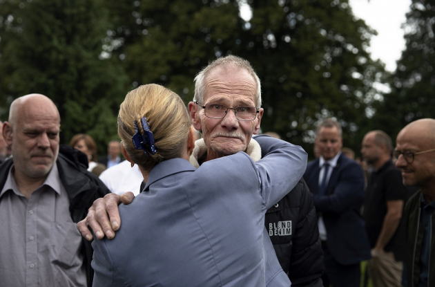 Prime Minister Mette Frederiksen embraces an old man