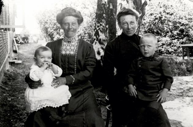 Two South Jutland women, each with their child on their lap