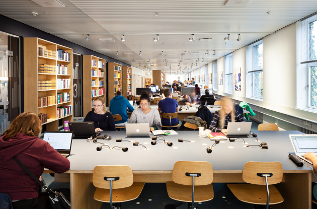 Students with laptops in library room