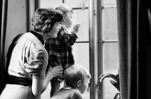 Mor og børn venter ved vinduet