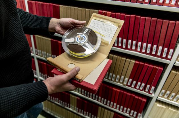 Employee presents reel-to-reel tape from Det Kgl. Bibliotek's collections