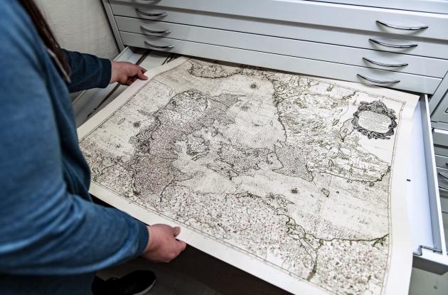 Medarbejder fremviser danmarkskort fra Det Kgl. Biblioteks samlinger