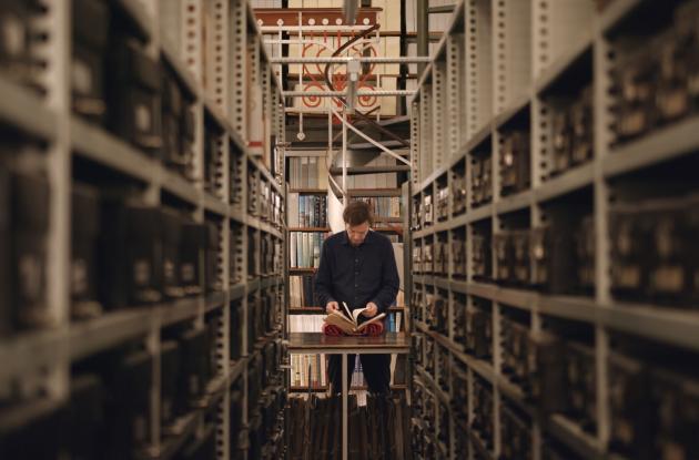 Anders Toftgaard flips through books in Det Kgl. Bibliotek's Danish Hall. Still from the movie A Word for Human