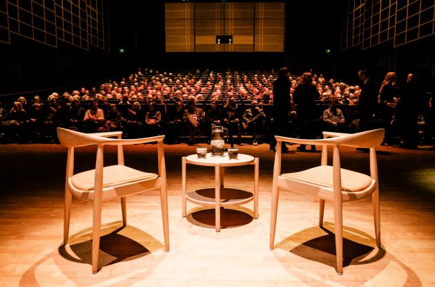 Two chairs on stage for the International Authors' Stage while the audience finds their seats