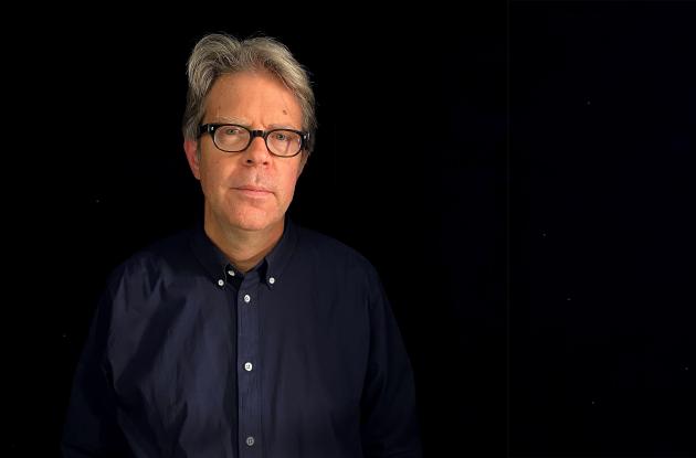 Forfatter Jonathan Franzen i blå skjorte på sort baggrund
