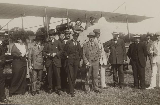 Press people stand ready in front of an airplane to take off