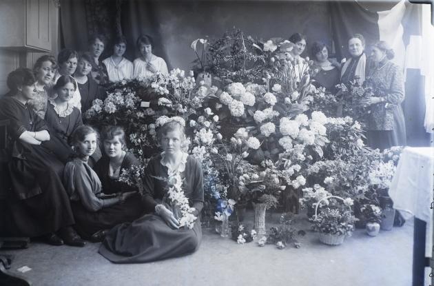 En gruppe kvinder ved siden af en masse blomster