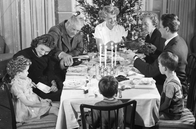 En familie sidder omkring julebordet