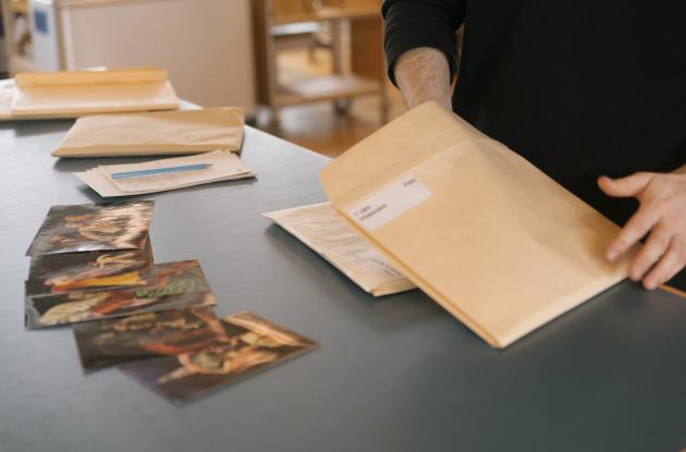 Mand tager billeder ud af en konvolut