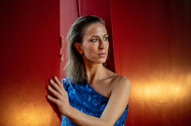 Billede af Mathilde Falch foran en rødorange baggrund.