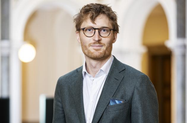 Billede af Kristian Cedervall Lauta i en sal med sort- og hvidternet gulv.