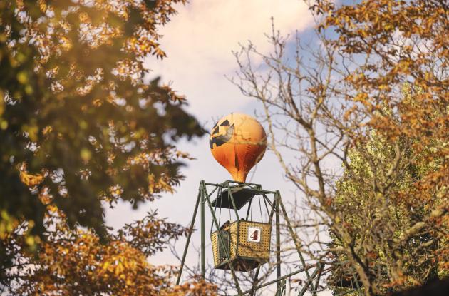 The balloon swings in Tivoli decorated for Halloween. Photographed through autumn leaves.