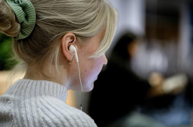 Kvinde lytter via høretelefoner