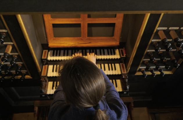 Billede næsten ovenfra af en kvinde der sidder og spiller på orglet i Roskilde Domkirke