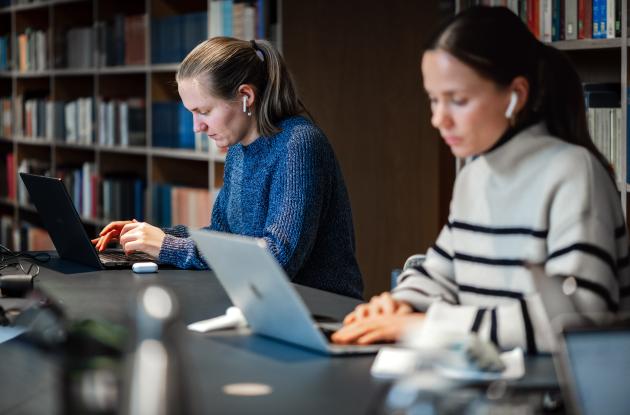 studerende med computere på bibliotek