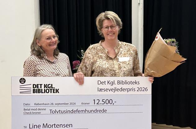 Bente Skovgaard Kristensen, direktør for Det Kgl. Bibliotek, og Line Mortensen, prismodtager, med check og blomster ved prisoverrækkelse.