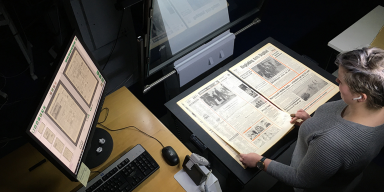 Medarbejder i færd med digital affotografering af avis