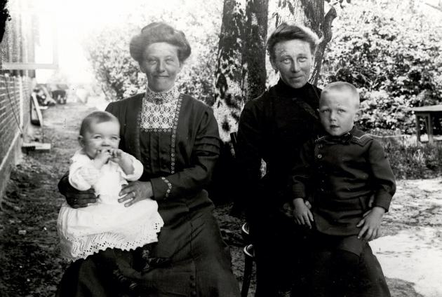 Two South Jutland women, each with their child on their lap