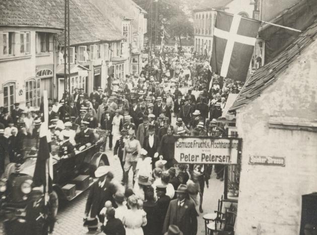 The royal family drives into Tønder. Signs in German.