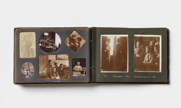 A photo album is open with two pages covered in old family photos