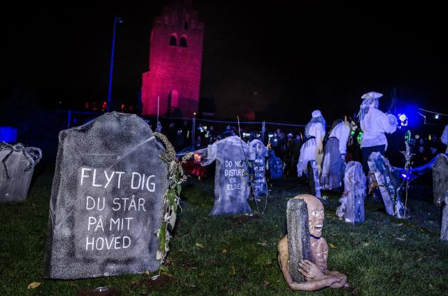 En kirkegård er blevet sat op som pynt til Halloween. På stenene står: "Flyt dig du står på mit hoved" og "Do not disturb or else!"