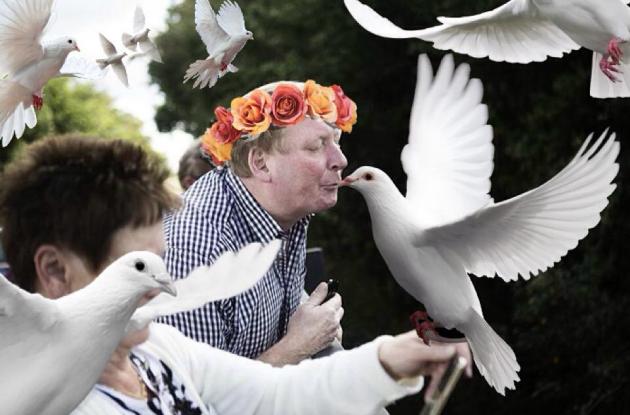 Photoshop af mand, der spytter ud over bro, hvor han nu bærer blomsterkrans og kysser en hvid due.