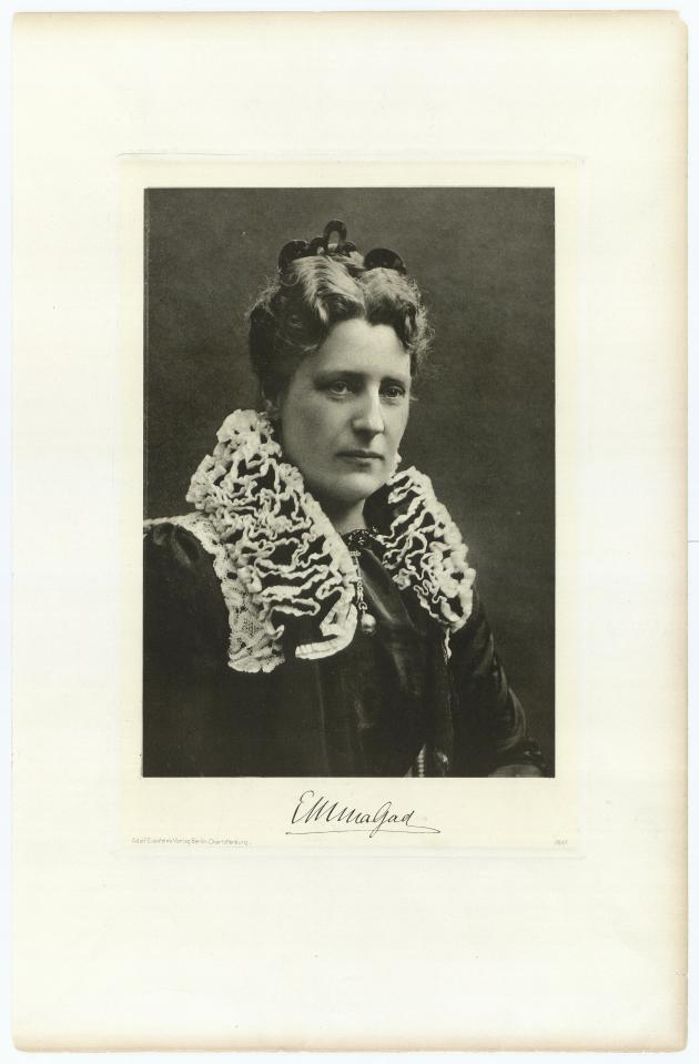 Author Emma Gad with big collar and high updo.