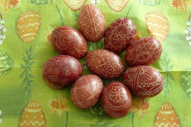 Decorated Easter eggs lie on a green and yellow napkin.