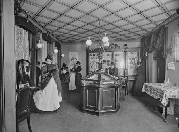 Inside a women's hairdresser's. In the middle is a display case, on the left side hair is being arranged