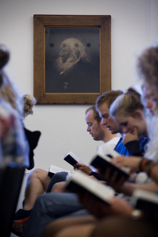 Mennesker synger højt fra en højskolesangbog.