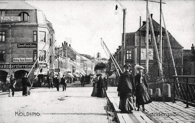 En gade med en masse mennesker og skilte til forretninger.