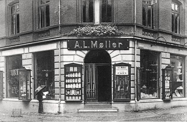 En dør til en forretning med et skilt over. På skiltet står "A.L. Møller".