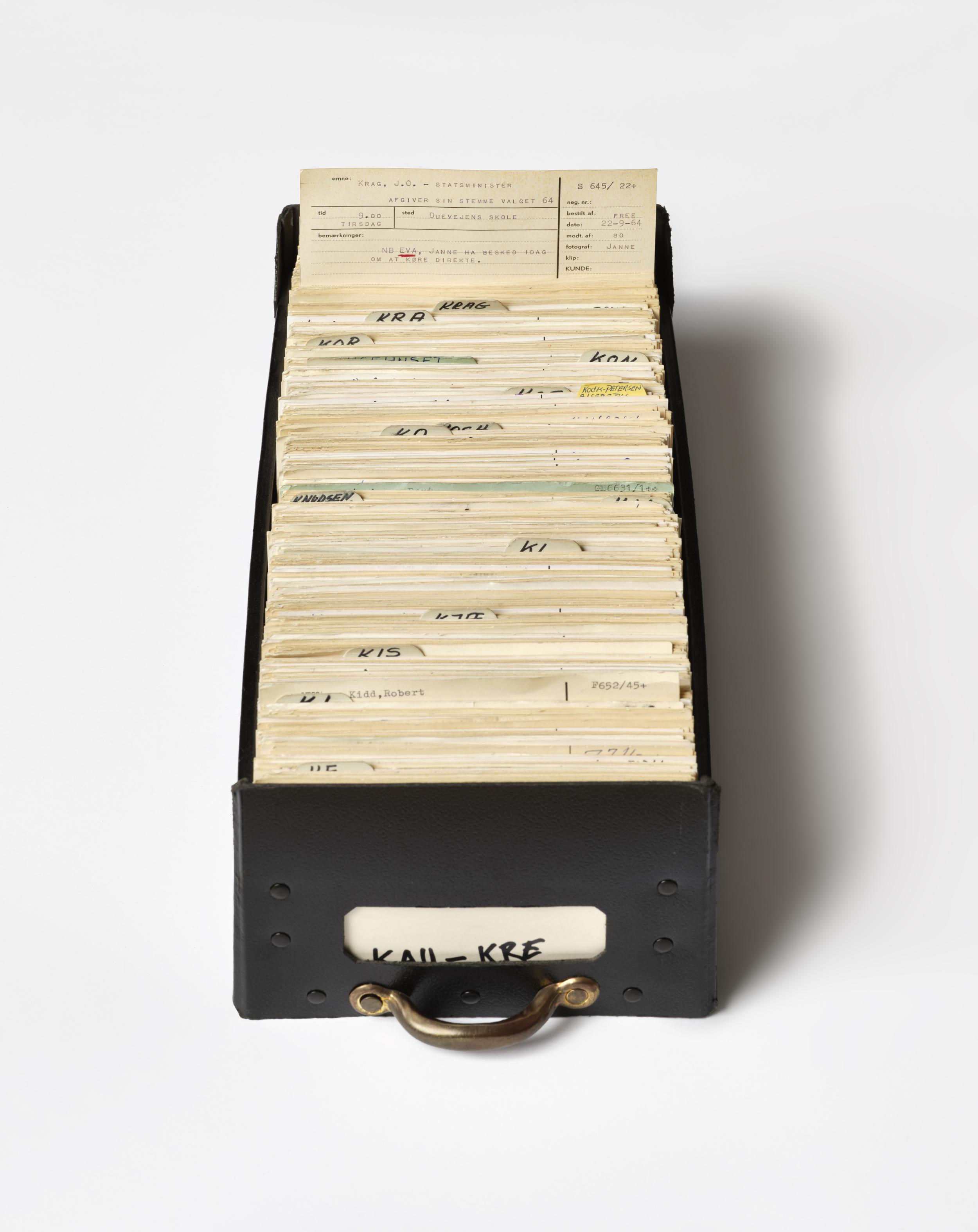 Sort kartotekskasse fra Pressehuset, hvor én af arkivkortene stikker op fra skuffen