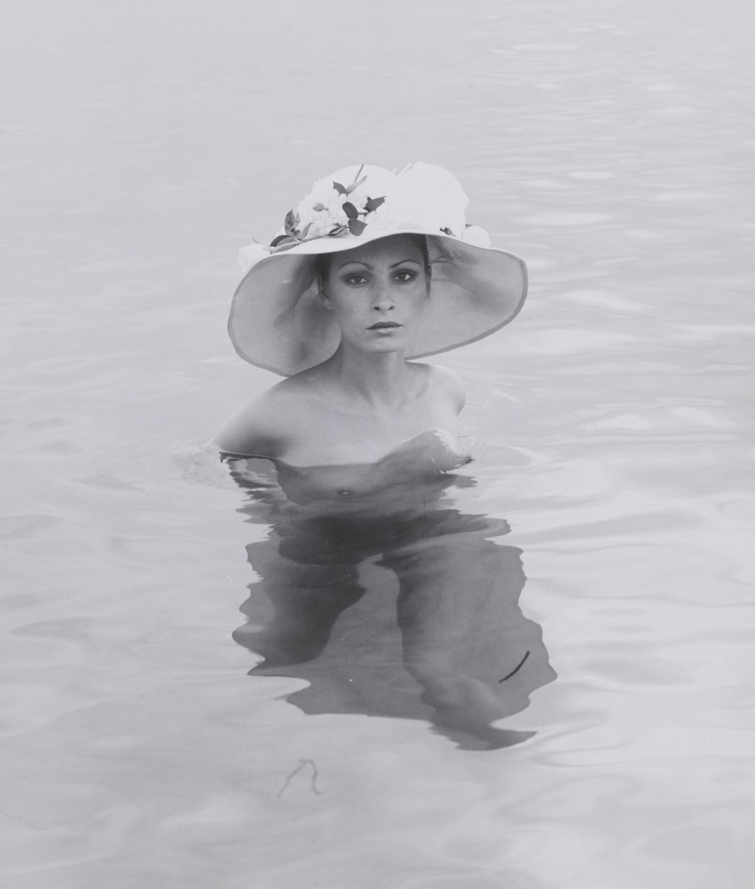 Kvinde bader nøgen med solhat