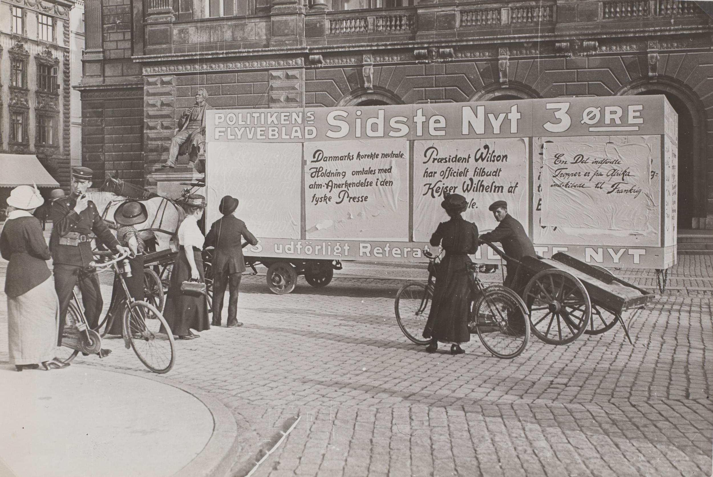 En gruppe mennesker ser på en vogn med nyheder.