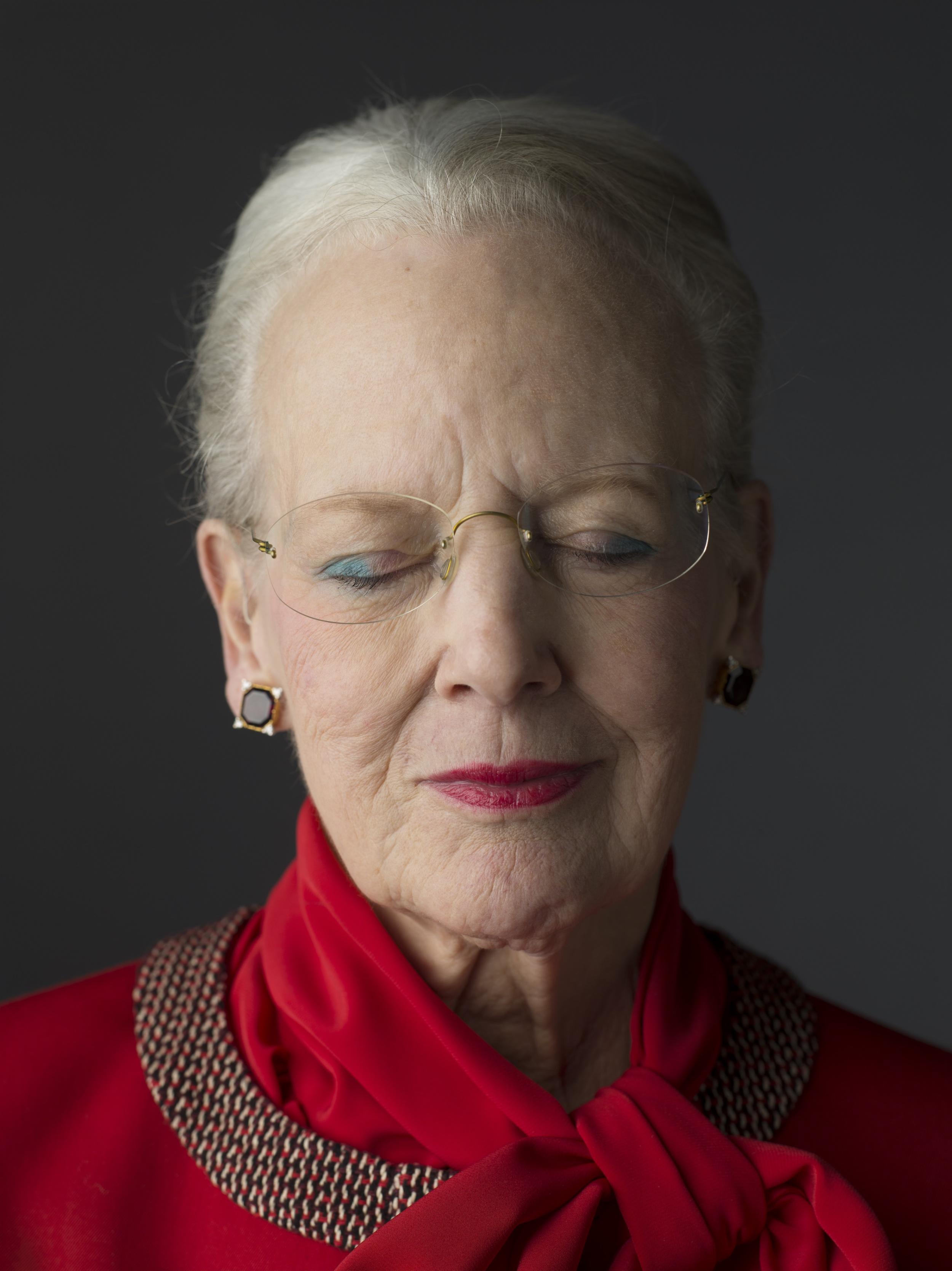 Portræt i farver af Dronning Margrethe II, der lukker sine øjne. Hun er klædt i rødt og har rød læbestift på.