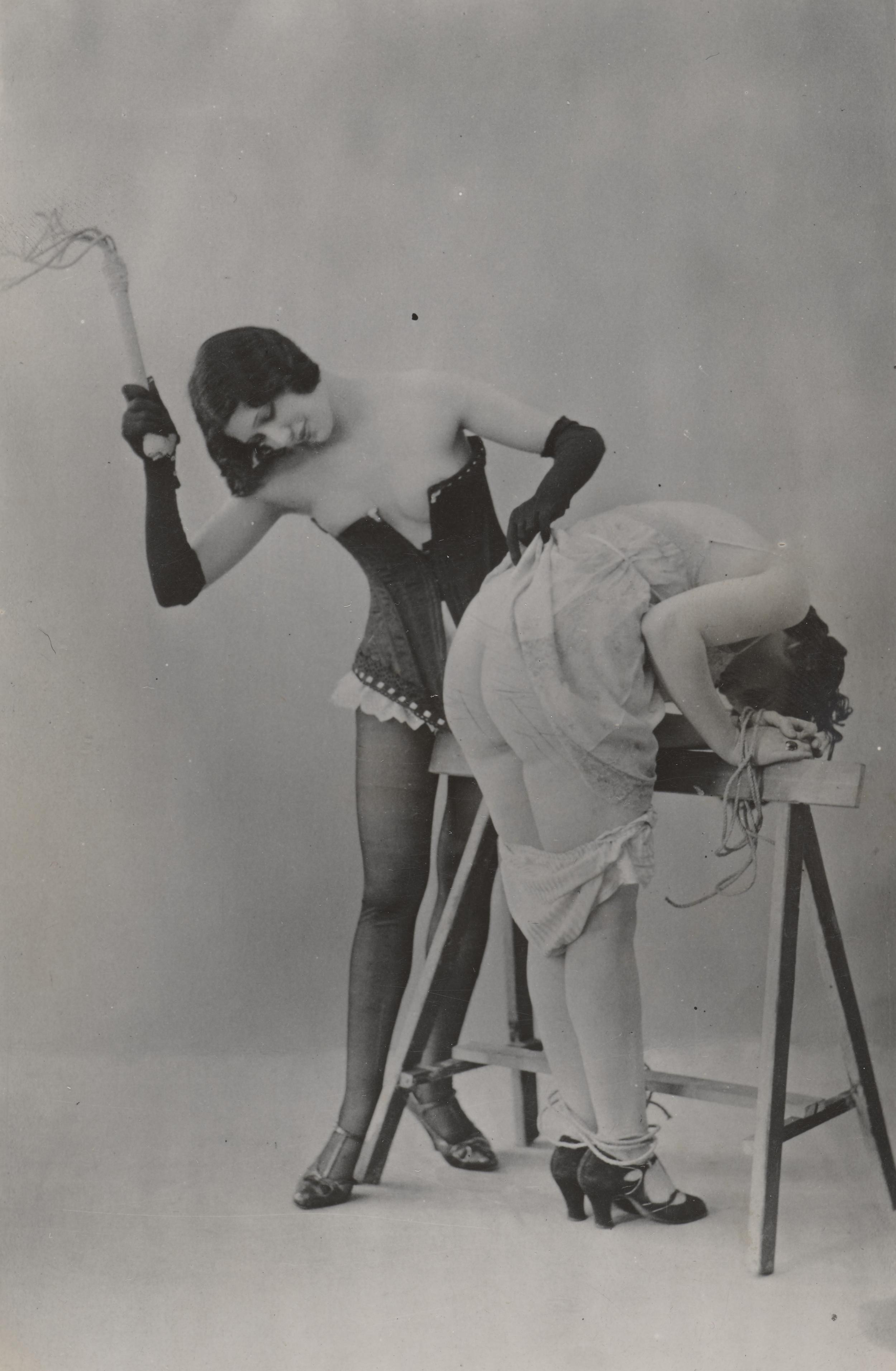 Kvinde svinger pisk mod anden kvindes bagparti