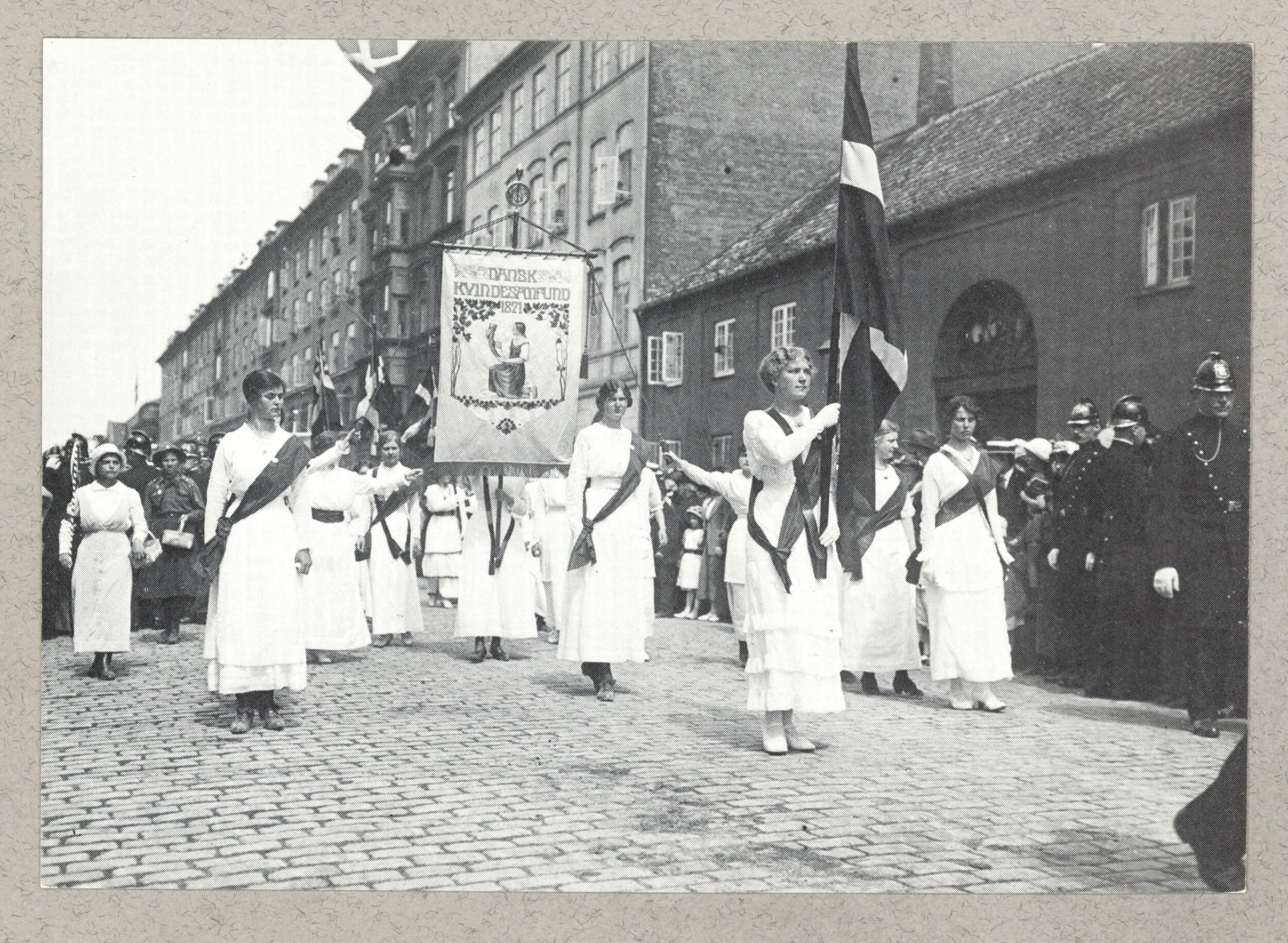 Kvindetoget går igennem København med bannere og flag.