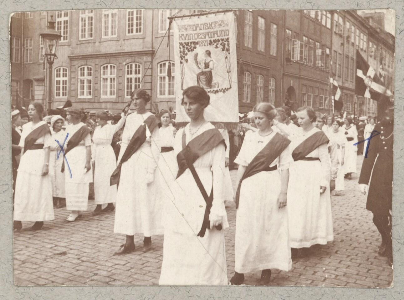 Kvindetoget går mod Amalienborg med bannere og flag.