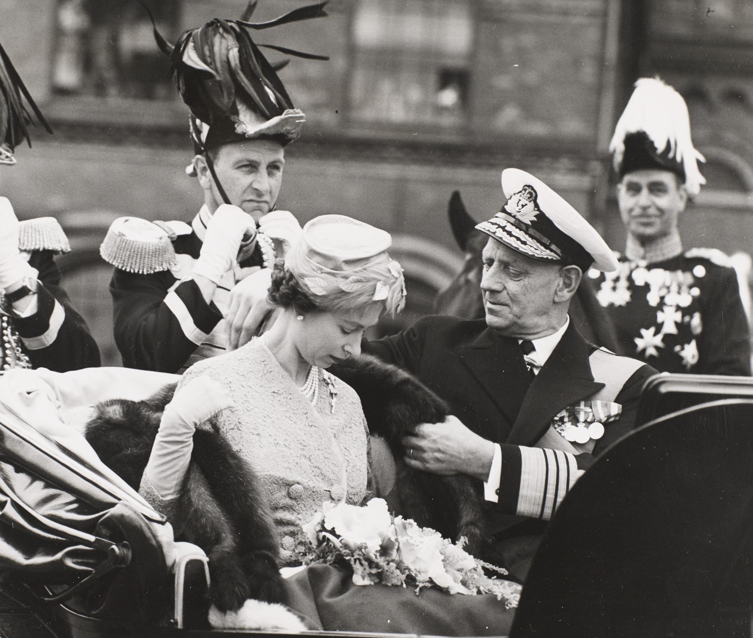 Frederik IX giver Elizabeth II pels på i karet